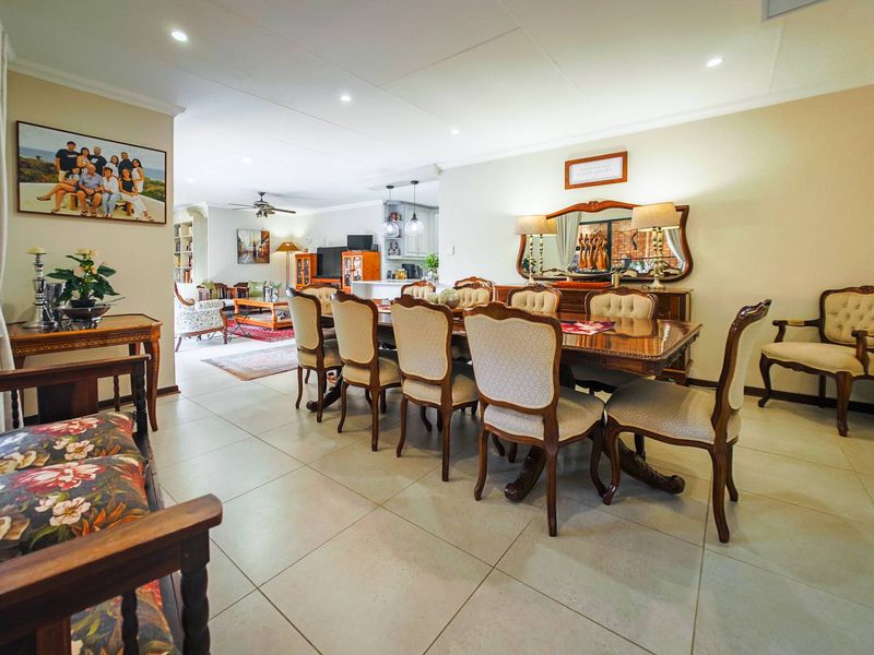 Spacious open-plan dining and living area featuring neutral tiled flooring and recessed downlighting, creating a bright and functional family space.