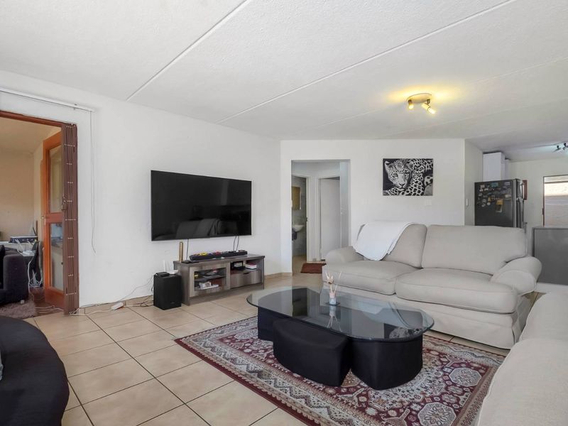 A spacious living room featuring tiled flooring and neutral walls, providing a functional and open layout for comfortable daily living.