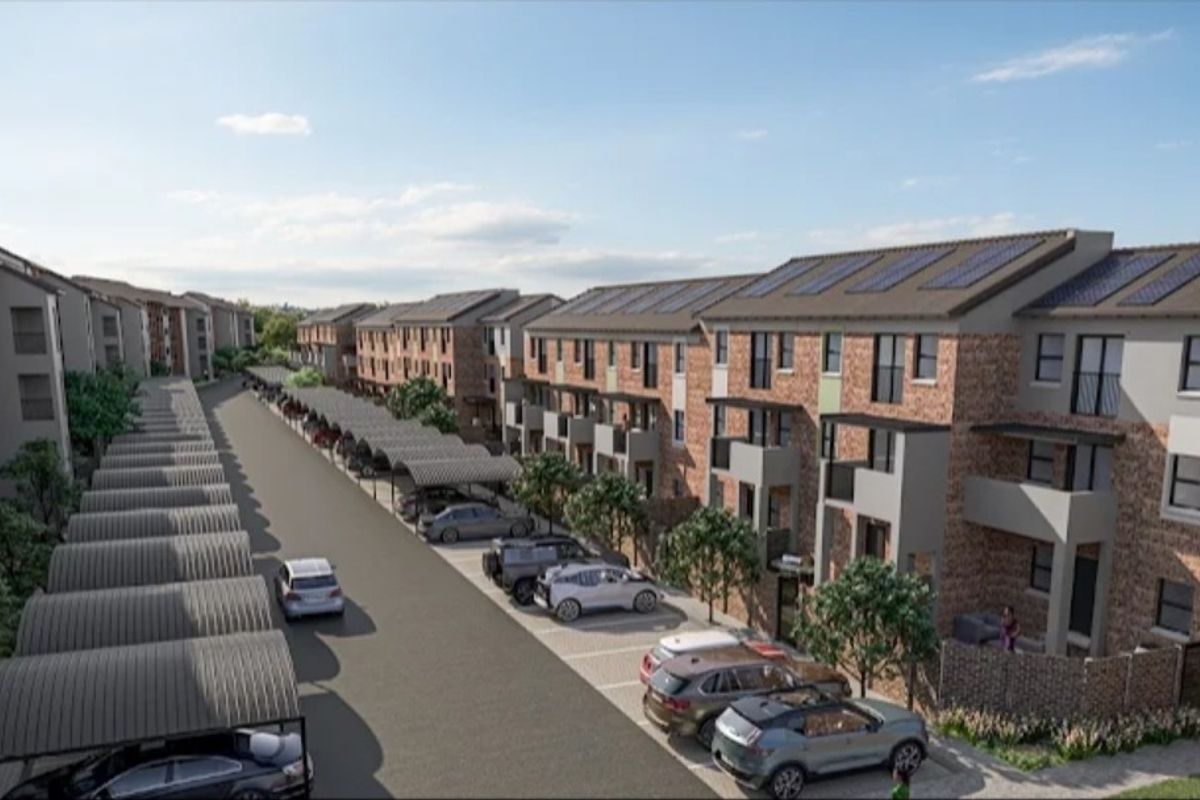 Aerial view of a modern apartment complex featuring brick facades, private balconies, solar panels, and dedicated covered parking bays.