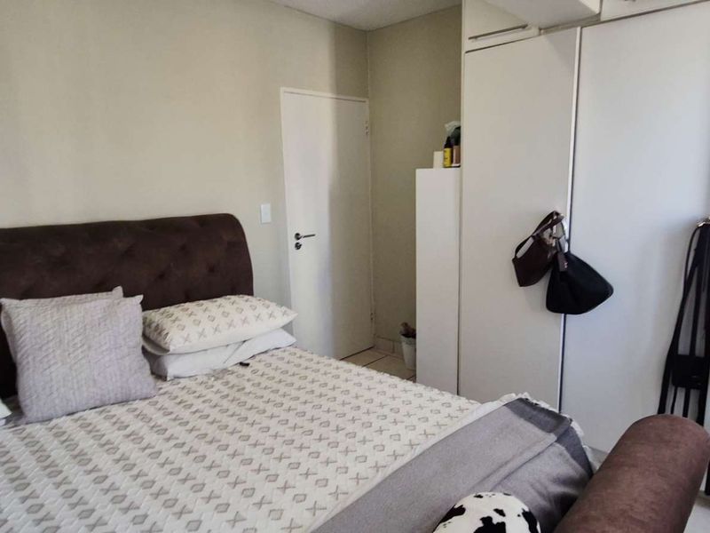 A functional bedroom featuring built-in cupboards and neutral wall finishes, providing a practical space for rest and storage.