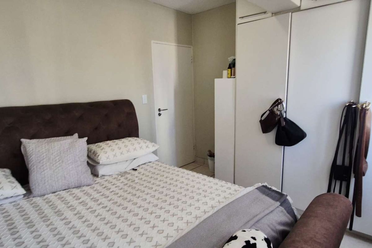 A functional bedroom featuring built-in cupboards and neutral wall finishes, providing a practical space for rest and storage.