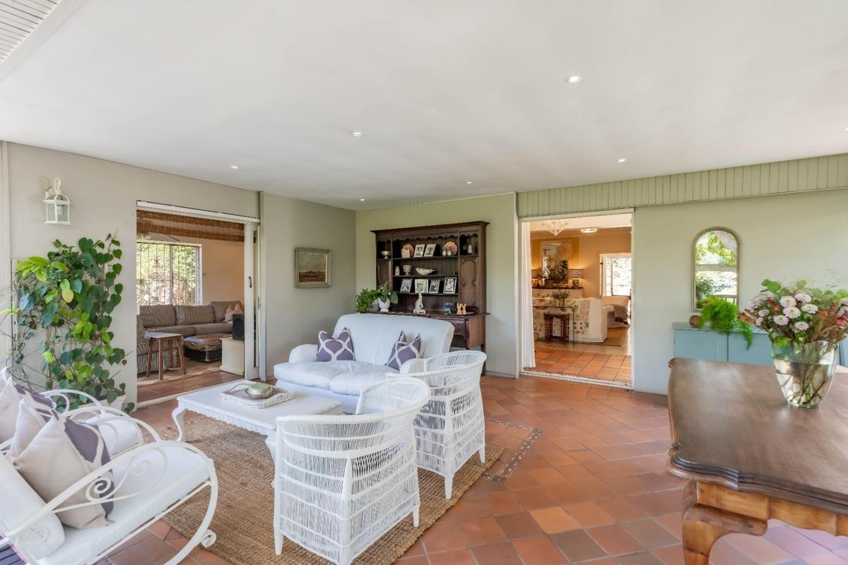 Spacious living area featuring terracotta tile flooring, recessed lighting, and seamless access to adjacent rooms through large sliding glass doors.