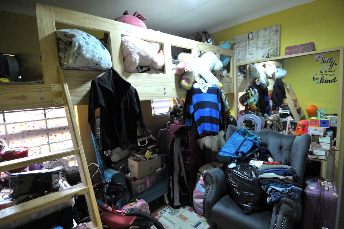A bedroom featuring a built-in mirror and coving, currently utilized as a children's room with significant personal belongings and furniture.
