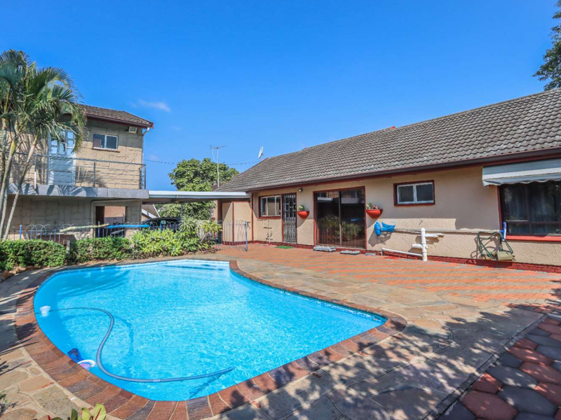 Outdoor pool area featuring a paved patio, swimming pool, and direct access to the main house via sliding glass doors.