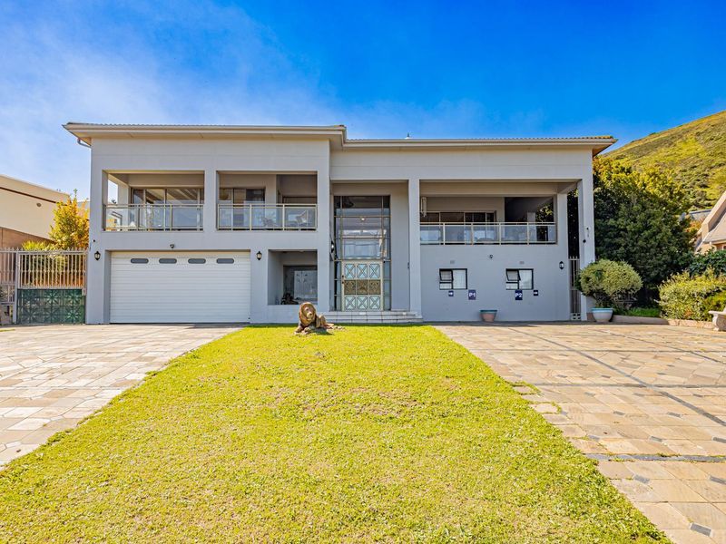 A well-maintained double-story residential property featuring a paved driveway, integrated double garage, and upper-level balconies with glass balustrades.