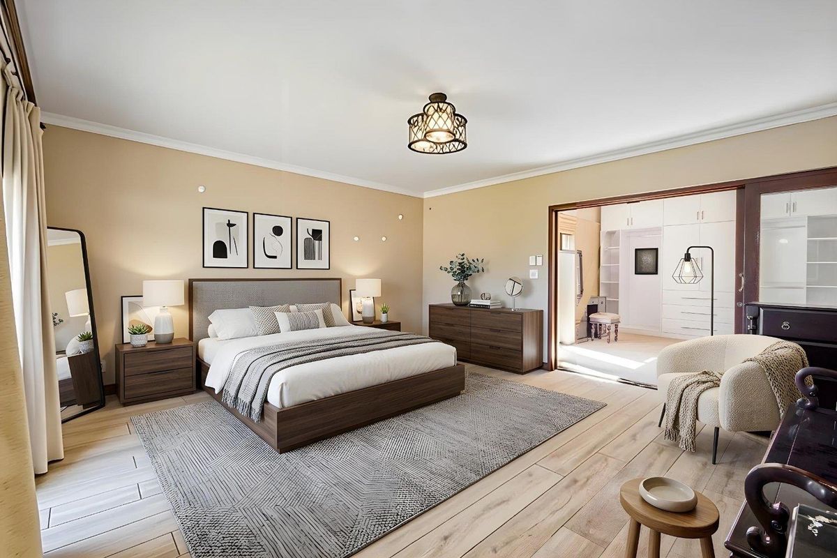 Spacious bedroom featuring light wood-look laminate flooring, neutral wall tones, and an adjoining walk-in closet area with extensive built-in cabinetry.