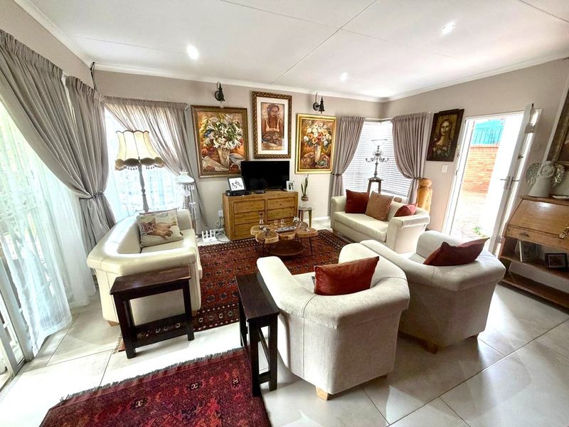 A well-maintained living room featuring tiled flooring, recessed lighting, and direct access to the outdoor area through a sliding glass door.