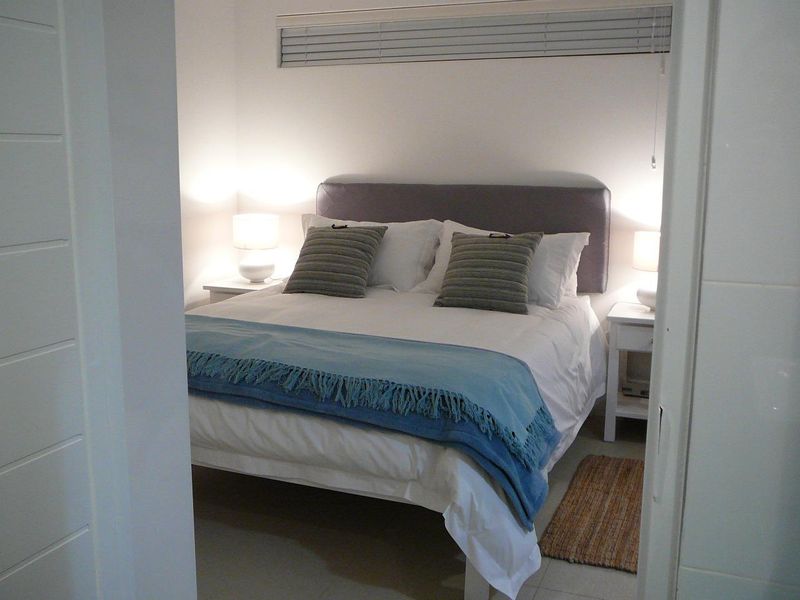 A well-maintained bedroom featuring neutral tiled flooring and horizontal venetian blinds, presented in a clean and tidy condition.