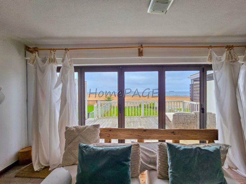 Living area featuring large sliding glass doors that provide direct access to an outdoor deck and scenic ocean views.