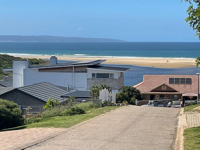 A scenic elevated view overlooking the coastal estuary, beach, and ocean, showcasing the surrounding residential neighbourhood landscape.
