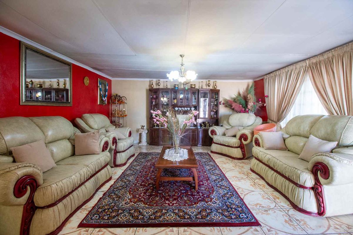 A spacious living room featuring tiled flooring and a coved ceiling, offering a traditional layout ready for modern updates.