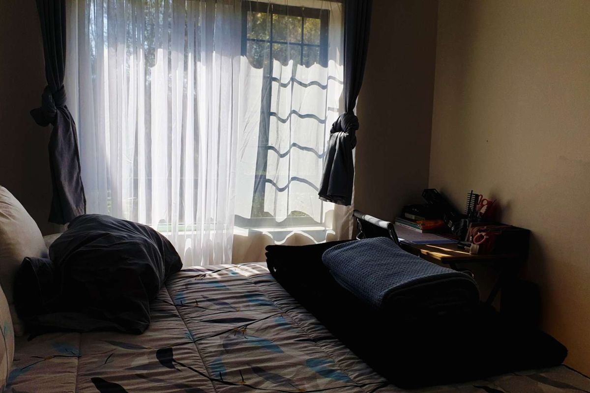 A bedroom featuring a window with natural light, providing a functional space for rest.