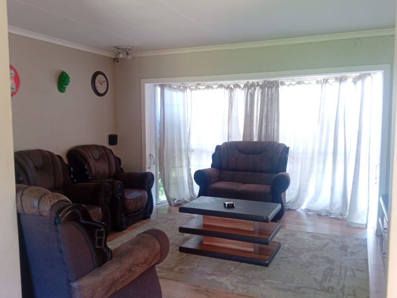 A comfortable living room featuring laminate flooring and a large sliding glass door that provides ample natural light.