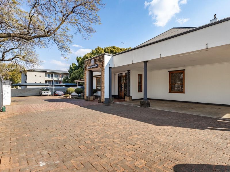 Front exterior view of the office building featuring a paved driveway, covered entrance porch, and stone architectural detailing.