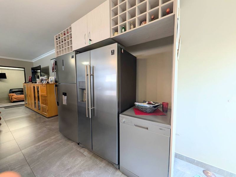 A functional kitchen area featuring custom built-in cabinetry with integrated wine storage and dedicated spaces for large appliances.