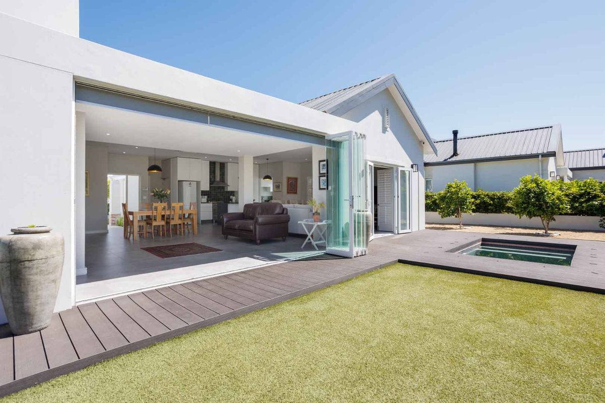 Open-plan living and dining area with seamless flow to a rear patio featuring composite decking and a small plunge pool.