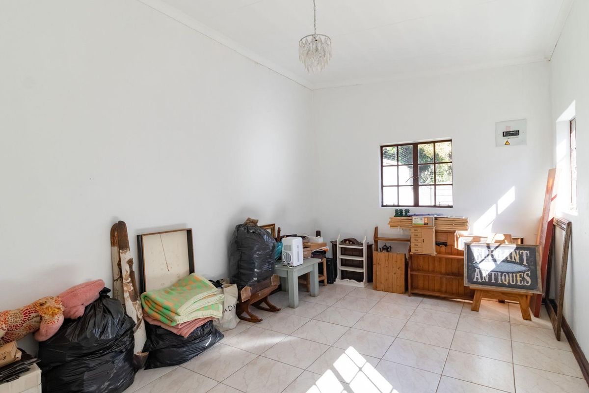 A versatile room featuring tiled flooring, a window for natural light, and a central light fixture, suitable for use as a bedroom or office space.