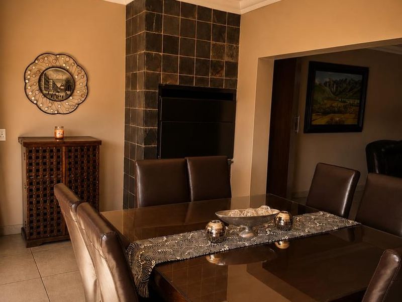Dining room featuring a built-in fireplace with dark tiled surround, neutral wall tones, and tiled flooring.