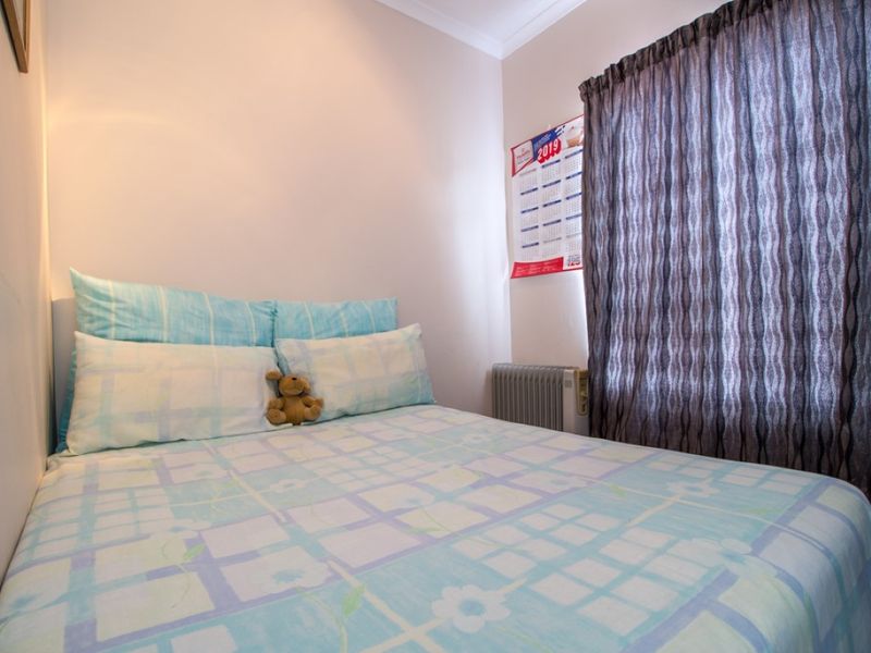 A compact bedroom featuring neutral walls, coving, and a wall-mounted electric radiator, providing a functional and cozy sleeping space.