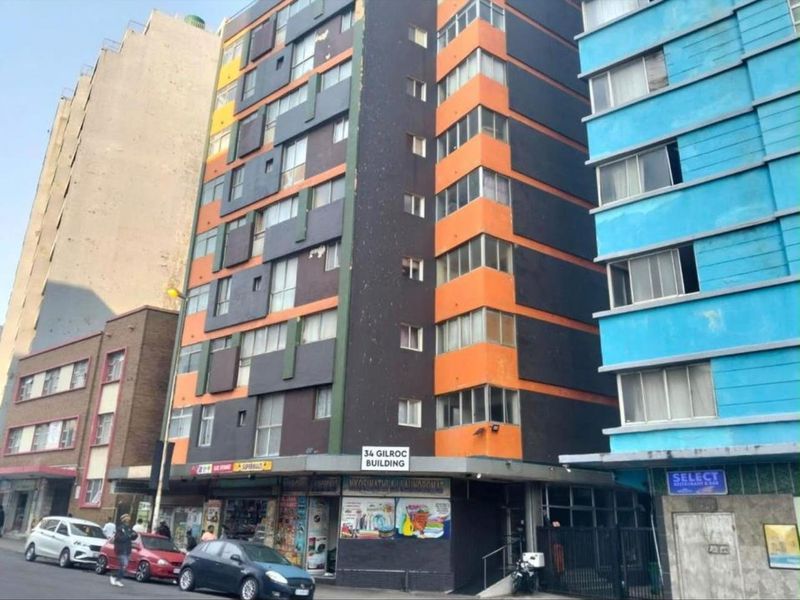 Exterior view of the multi-story Gilroc building featuring a commercial ground floor and residential upper levels with balconies.