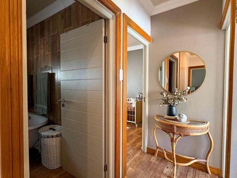 A well-maintained hallway featuring timber flooring and matching timber door frames, providing access to adjacent rooms.