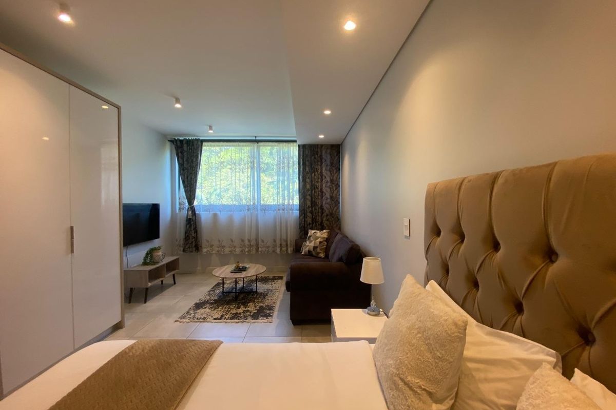 A well-maintained bedroom featuring tiled flooring, recessed downlighting, and a large built-in wardrobe, offering a comfortable and functional living space.