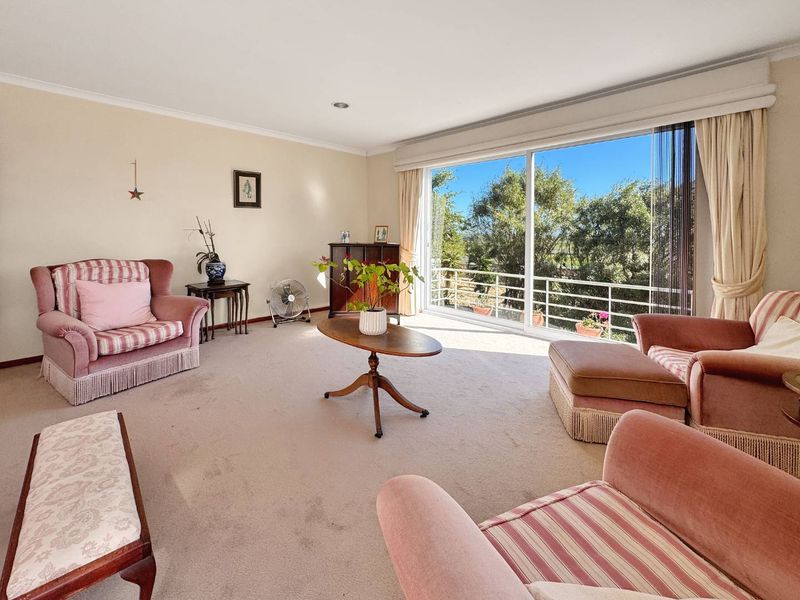 Spacious living room featuring large sliding glass doors that provide ample natural light and access to an outdoor balcony area.