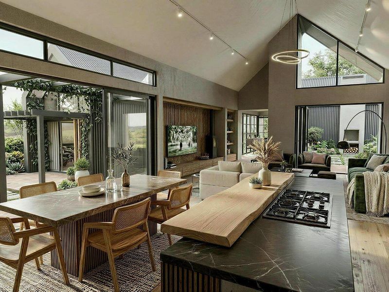 Spacious open-plan living area featuring a modern kitchen with a large island, high vaulted ceilings, and seamless indoor-outdoor flow to a landscaped patio.