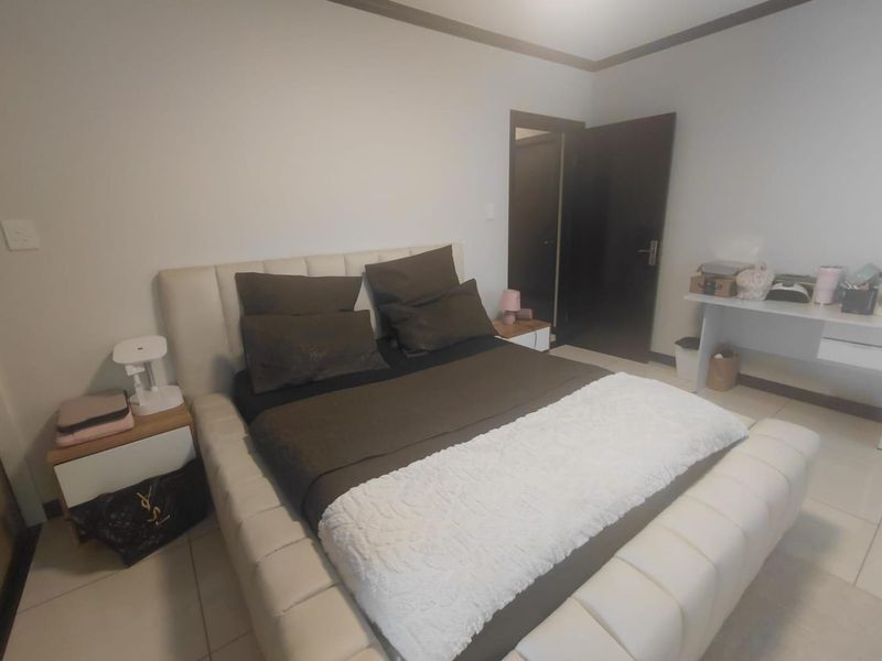 A bedroom featuring tiled flooring and a dark-toned internal door, providing a neutral base for interior design updates.