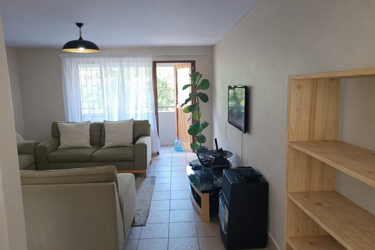 A living room featuring tiled flooring, a pendant light fixture, and direct access to an outdoor balcony area.