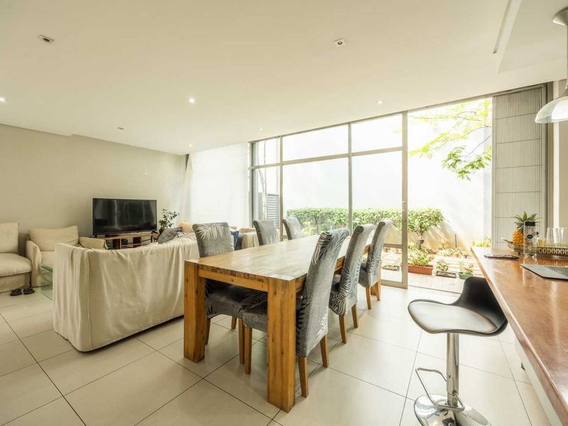 Spacious open-plan living and dining area featuring large sliding glass doors that provide abundant natural light and seamless access to the outdoor space.