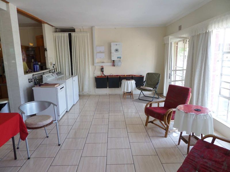 A functional laundry area featuring tiled flooring, integrated solar power infrastructure, and dedicated plumbing connections for laundry appliances.