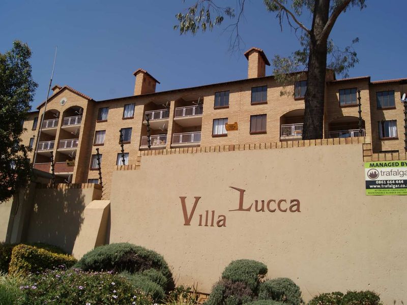 Exterior view of the Villa Lucca apartment complex featuring face brick architecture, private balconies, and secure perimeter walling.