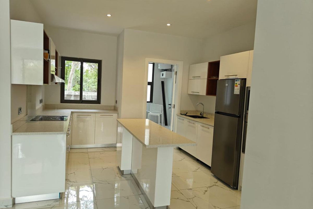 Modern kitchen featuring high-gloss cabinetry, stone countertops, a central breakfast island, and polished marble-look floor tiles.