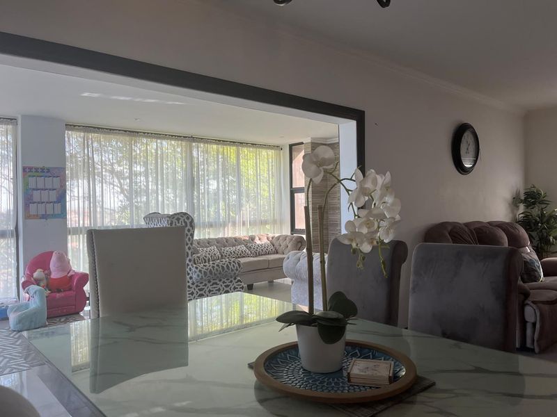 An open-plan living and dining area featuring large windows that provide ample natural light, creating a bright and connected living space.