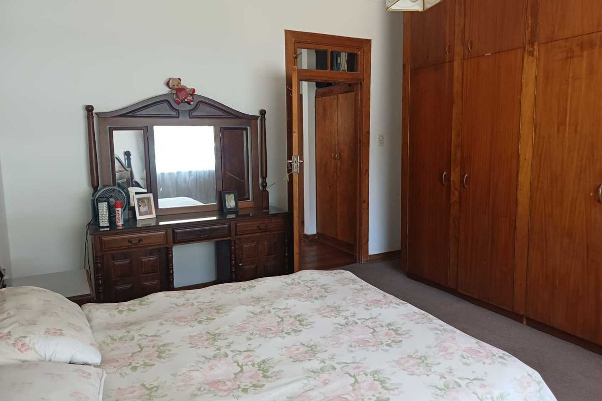 A bedroom featuring extensive built-in wooden cabinetry and a doorway leading to an adjacent space.