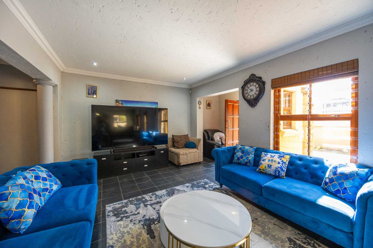 A comfortable living room featuring tiled flooring, recessed lighting, and crown molding, providing a functional space for relaxation and entertainment.