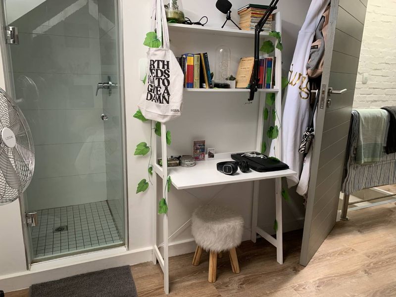 A bathroom featuring a glass-enclosed shower with tiled flooring and modern laminate wood-look flooring throughout the space.