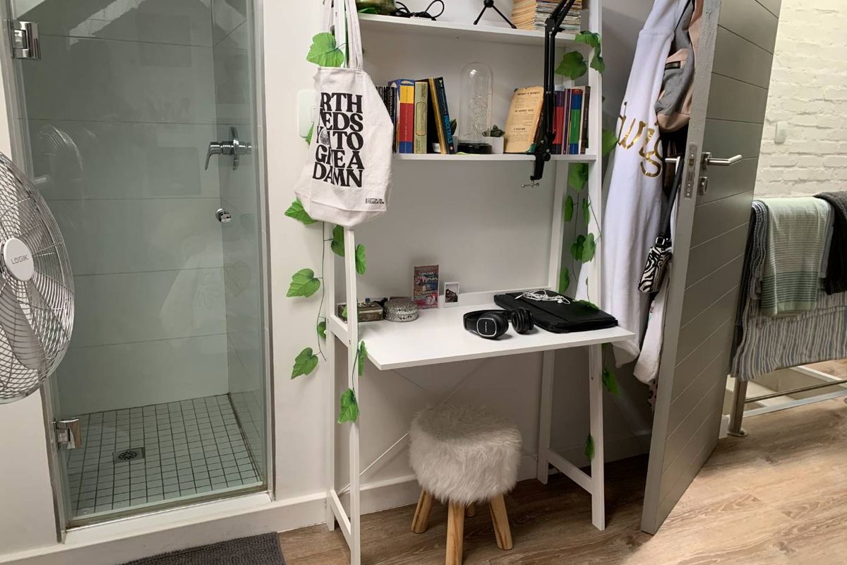 A bathroom featuring a glass-enclosed shower with tiled flooring and modern laminate wood-look flooring throughout the space.