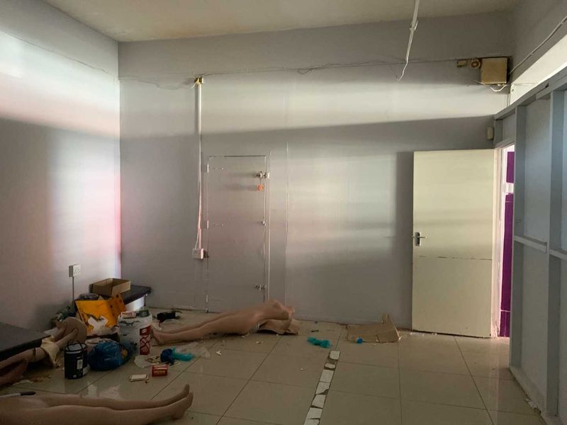 An empty utility or storage space featuring tiled flooring and exposed electrical conduit, requiring cosmetic updates and maintenance.