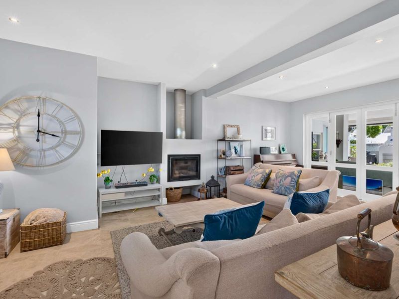 A bright and inviting living room featuring a built-in fireplace, recessed lighting, and large french doors that provide access to the outdoor area.