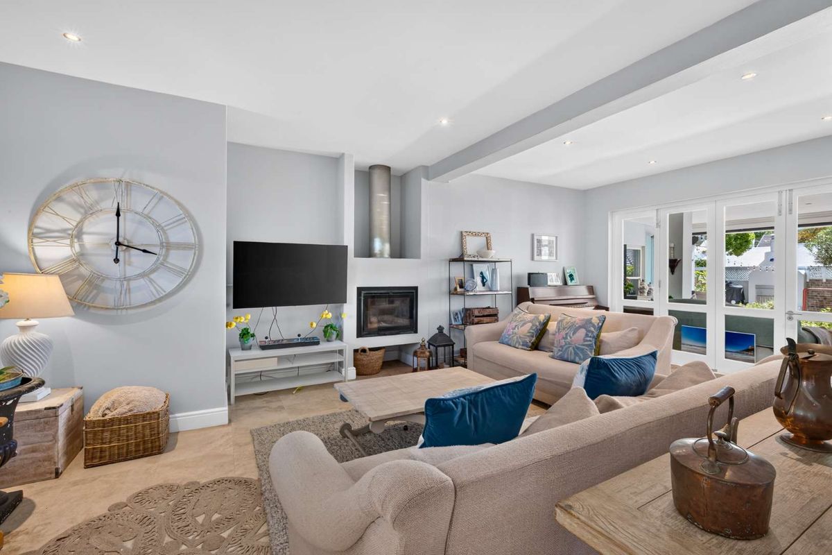 A bright and inviting living room featuring a built-in fireplace, recessed lighting, and large french doors that provide access to the outdoor area.