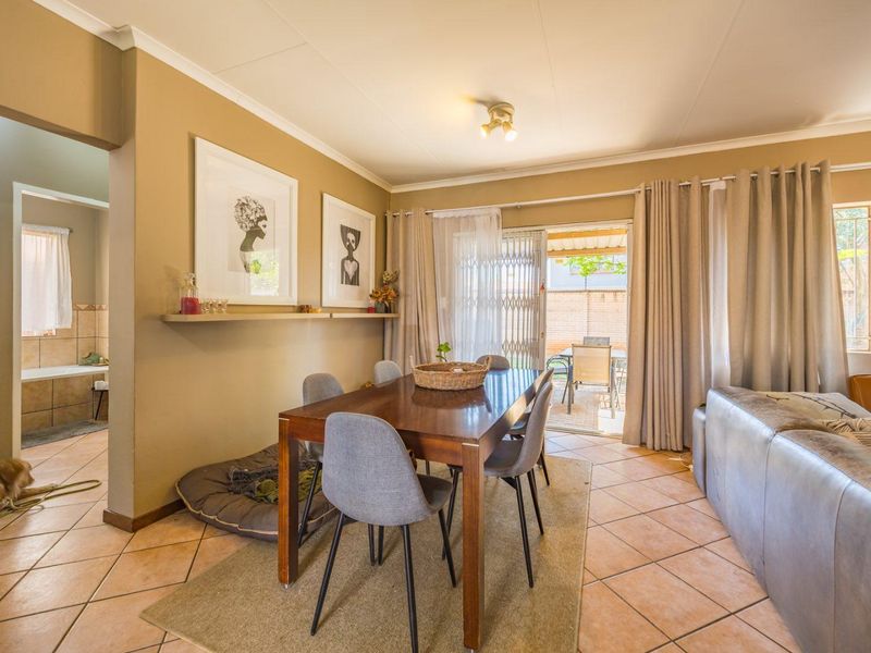 Open plan living and dining area featuring ceramic tile flooring, a floating shelf, and sliding glass doors providing access to the rear patio.