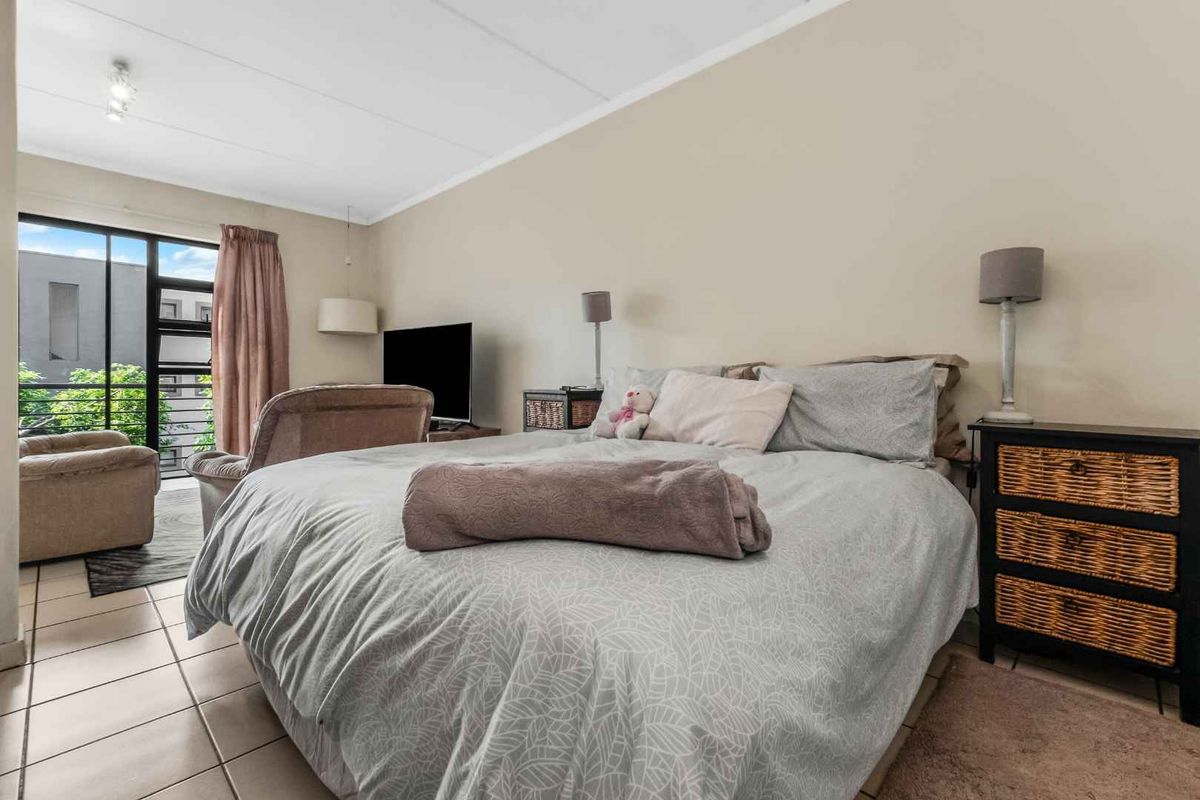 Spacious bedroom featuring tiled flooring and a sliding glass door providing access to an outdoor area.