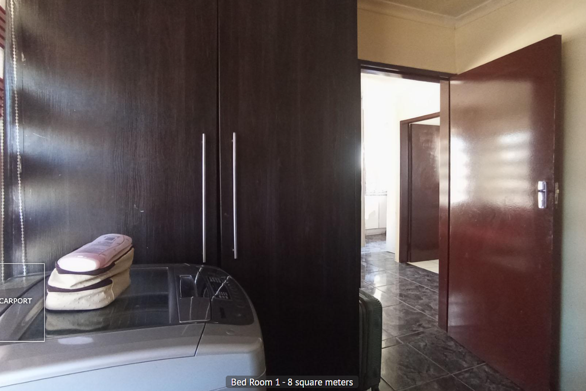 A bedroom featuring built-in dark wood cabinetry and tiled flooring, with a doorway leading to an adjacent interior space.