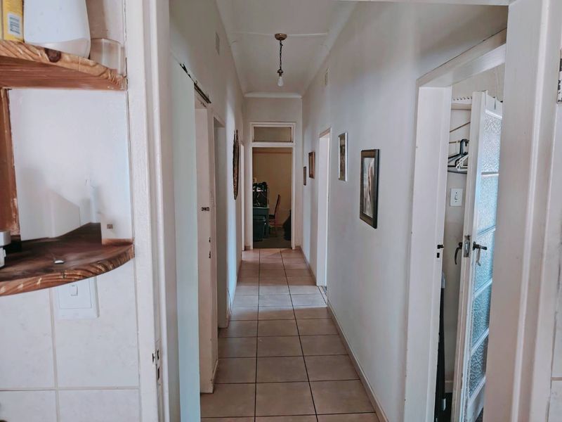A functional residential hallway featuring tiled flooring and access to multiple rooms, providing a central circulation space within the home.