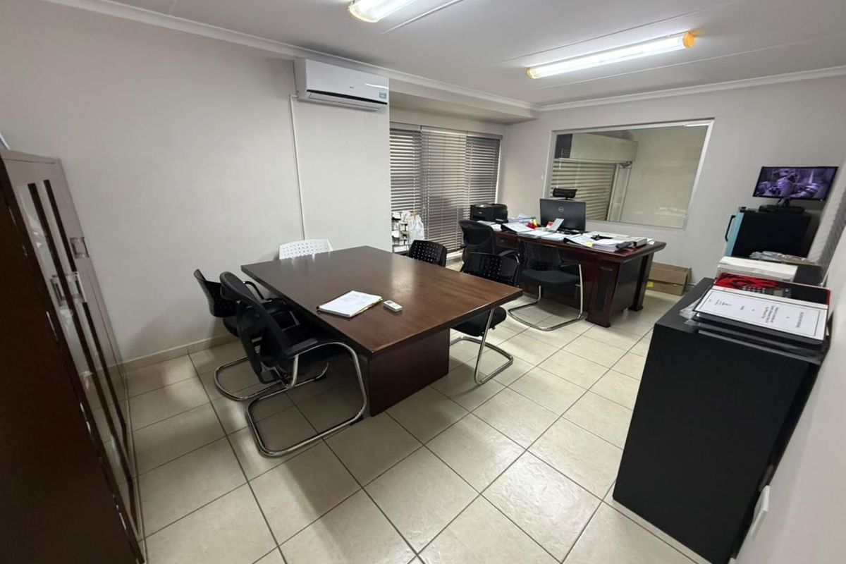 A functional office space featuring tiled flooring, air conditioning, and an internal window, providing a practical environment for professional use.