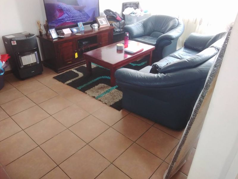 A living room area featuring tiled flooring, providing a functional space for relaxation and entertainment.