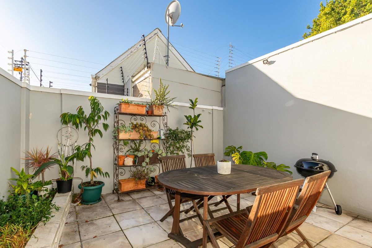 A private paved courtyard area featuring high perimeter walls, providing a secure and secluded outdoor space for relaxation and entertaining.