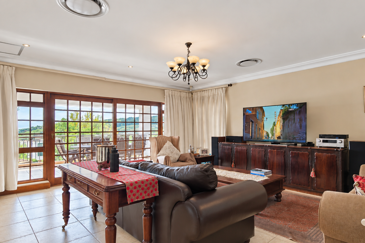 Spacious living room featuring tiled flooring, recessed lighting, and large sliding glass doors that provide access to the outdoor patio area.